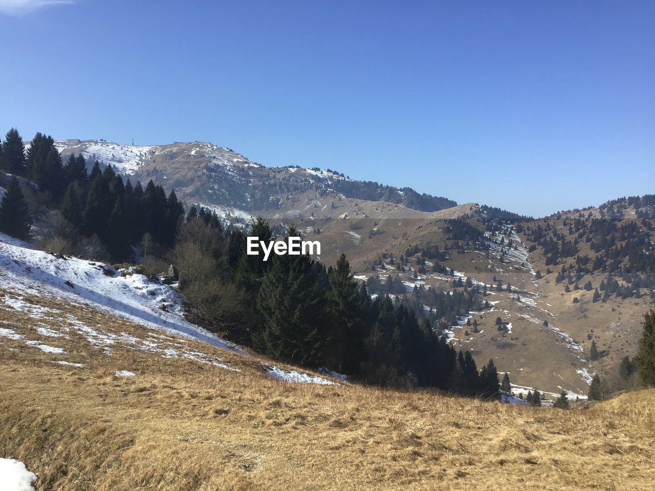 Scenic view of snowcapped mountains against clear blue sky