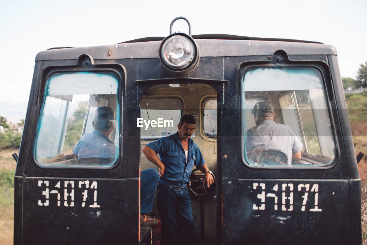 FULL LENGTH PORTRAIT OF A YOUNG MAN SITTING ON BUS