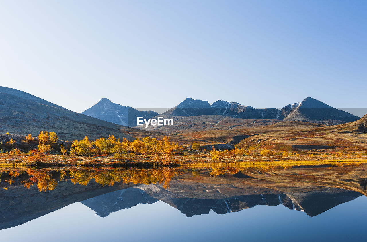 Reflection of rondane mountains in a small lake. rondane national park, norway, europe autumn colors