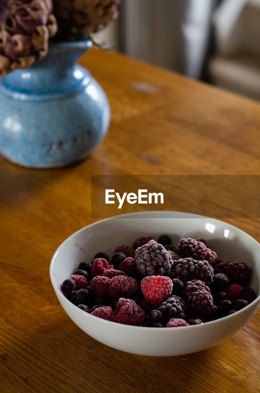 High angle view of a bowl full of berries on table