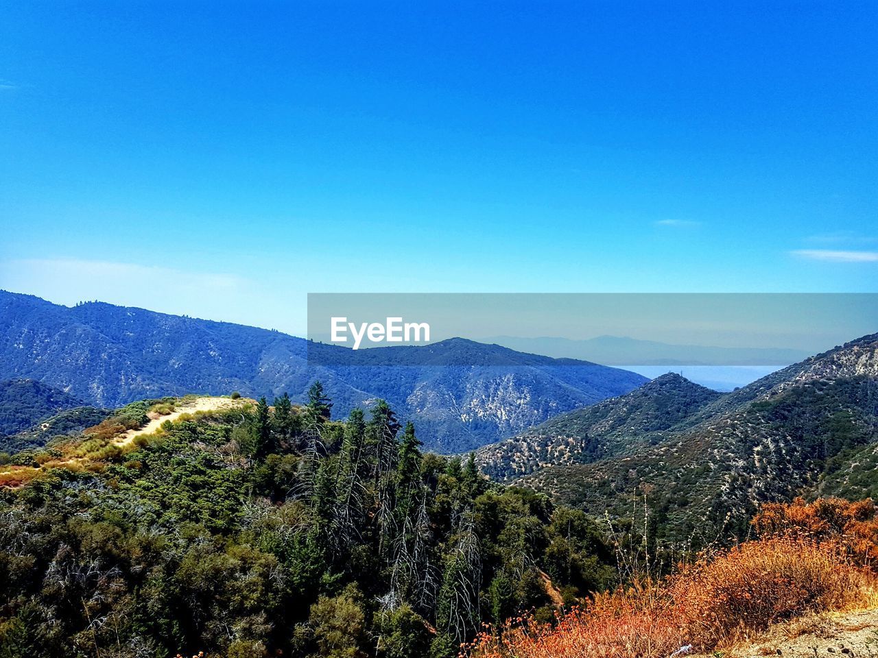 Scenic view of mountains against blue sky