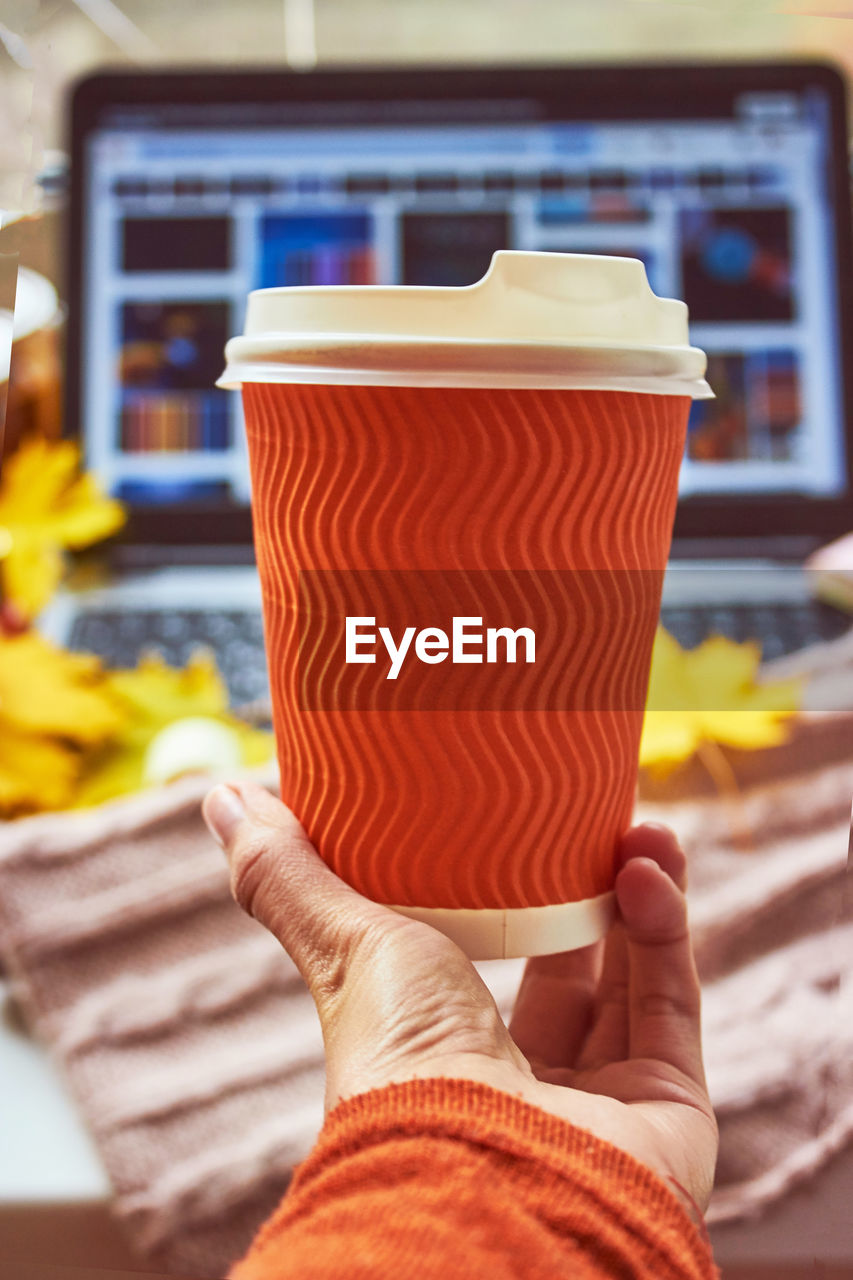 Paper orange coffee cup mock up close up. autumn atmosphere. vertical photo