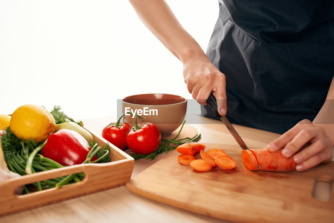 MIDSECTION OF MAN PREPARING FOOD IN KITCHEN