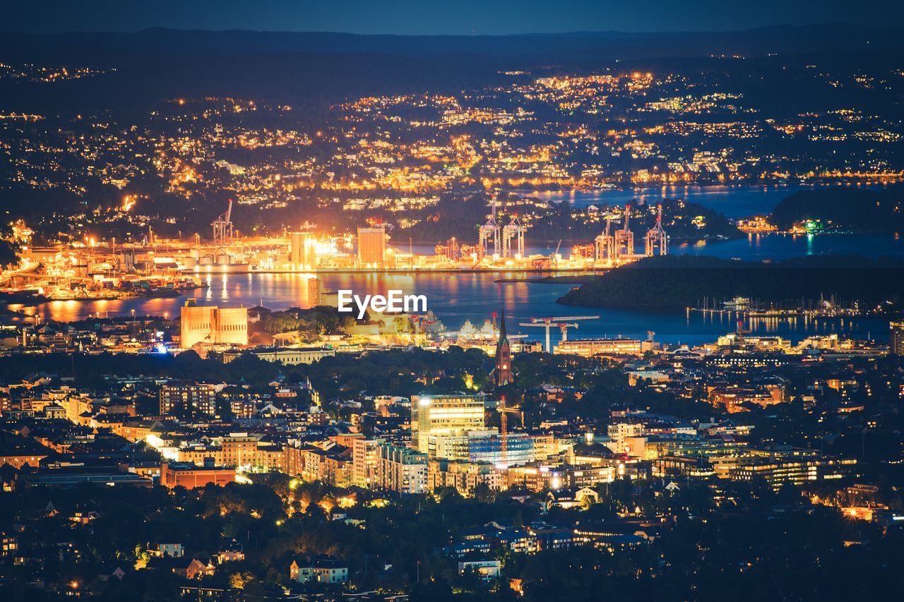 Aerial view of illuminated cityscape against sky at sunset