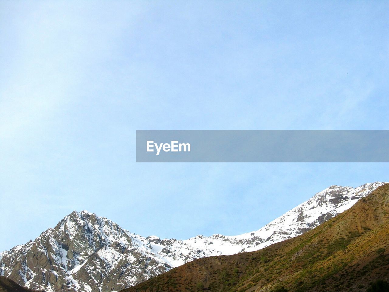 Low angle view of snowcapped mountains against sky