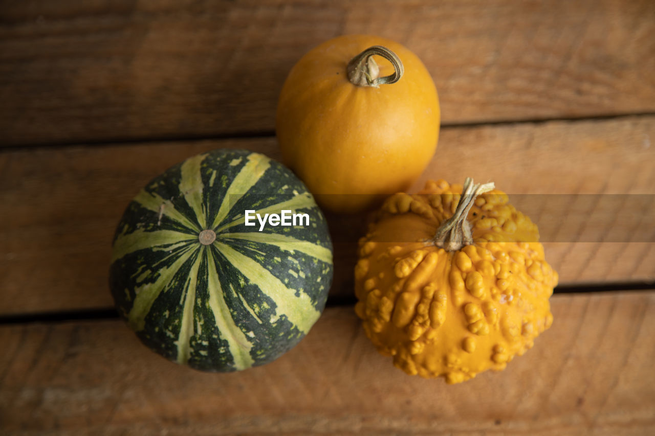 HIGH ANGLE VIEW OF PUMPKIN ON WOODEN TABLE