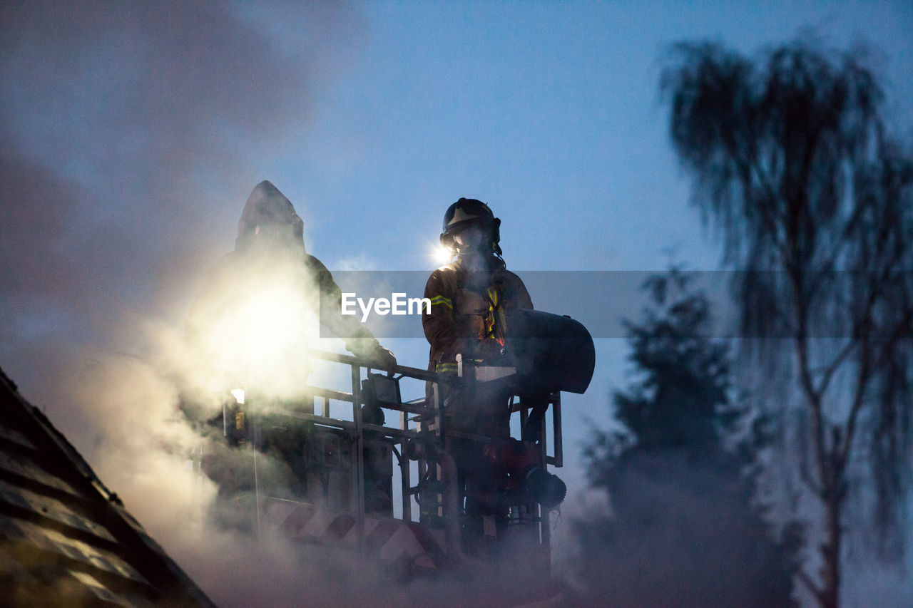 Low angle view of fire brigade on balcony against sky