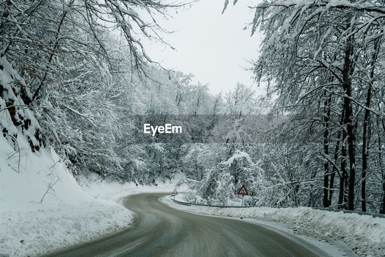 Road amidst snow covered land against sky