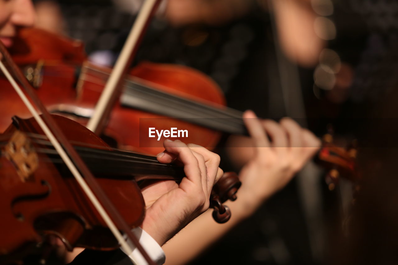 Cropped image of people playing violin