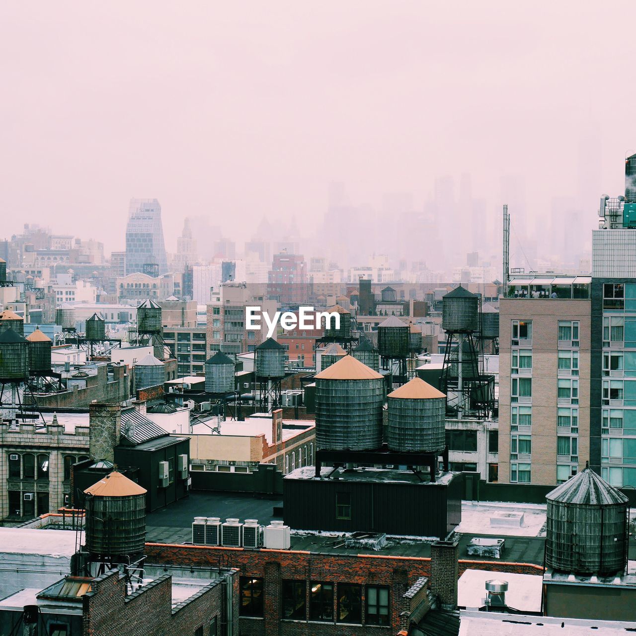 Cityscape against sky in foggy weather