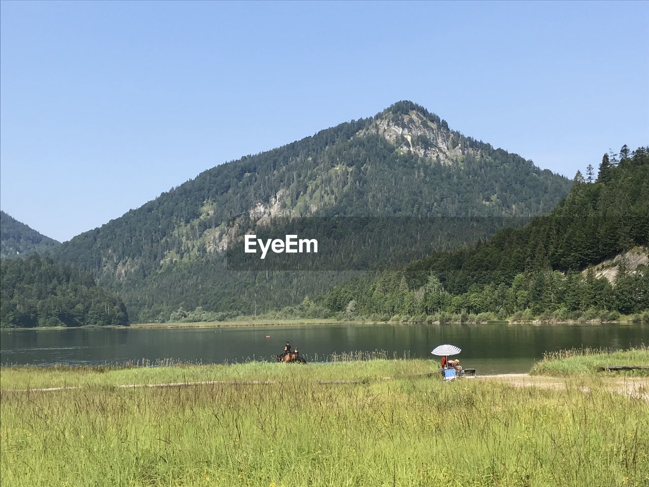 Scenic view of lake and mountains against clear sky