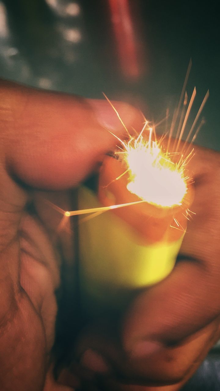 CLOSE-UP OF PERSON HAND HOLDING SPARKLER