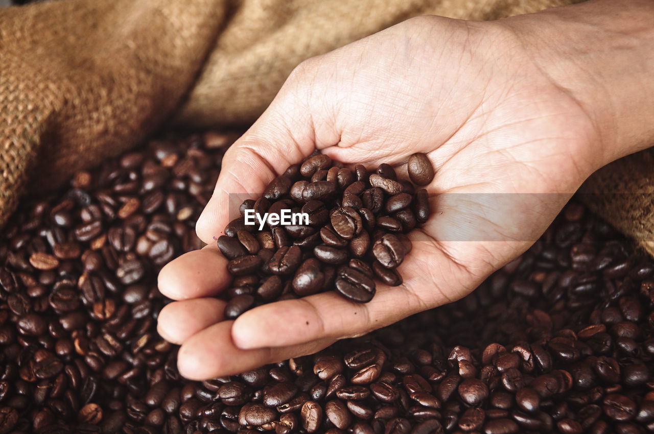 CLOSE-UP OF HAND HOLDING COFFEE