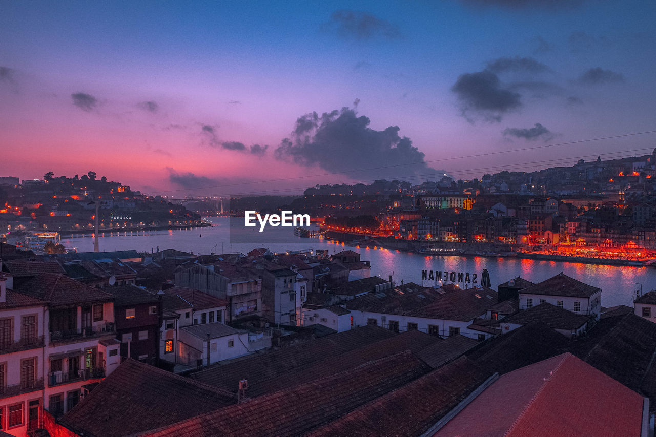 High angle view of illuminated buildings in city at sunset