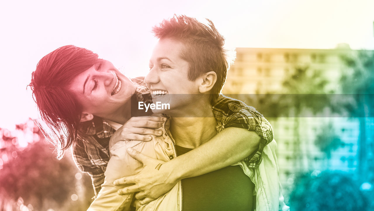 Smiling lesbian couple against buildings