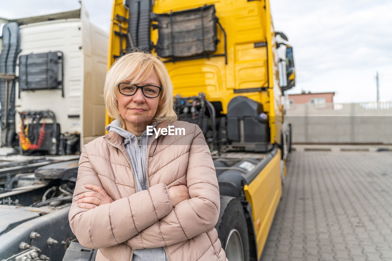 Portrait of mature woman standing by semi truck