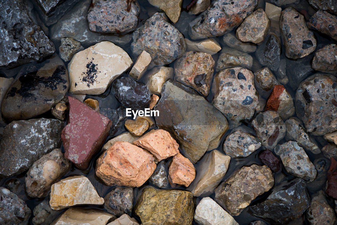 FULL FRAME SHOT OF PEBBLES ON SHORE