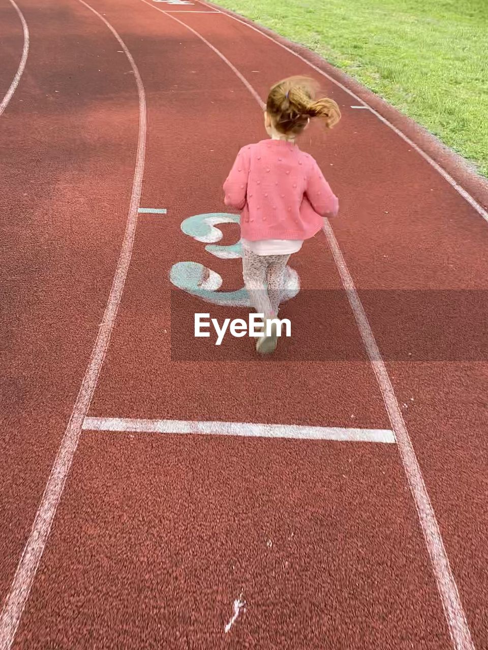 HIGH ANGLE VIEW OF GIRL RUNNING ON ROAD