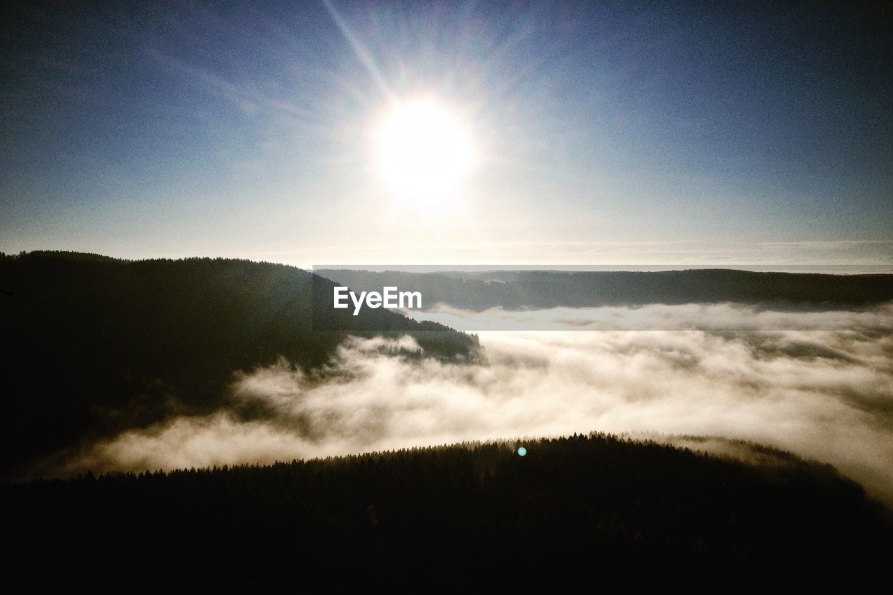 Clouds covering mountains against sky