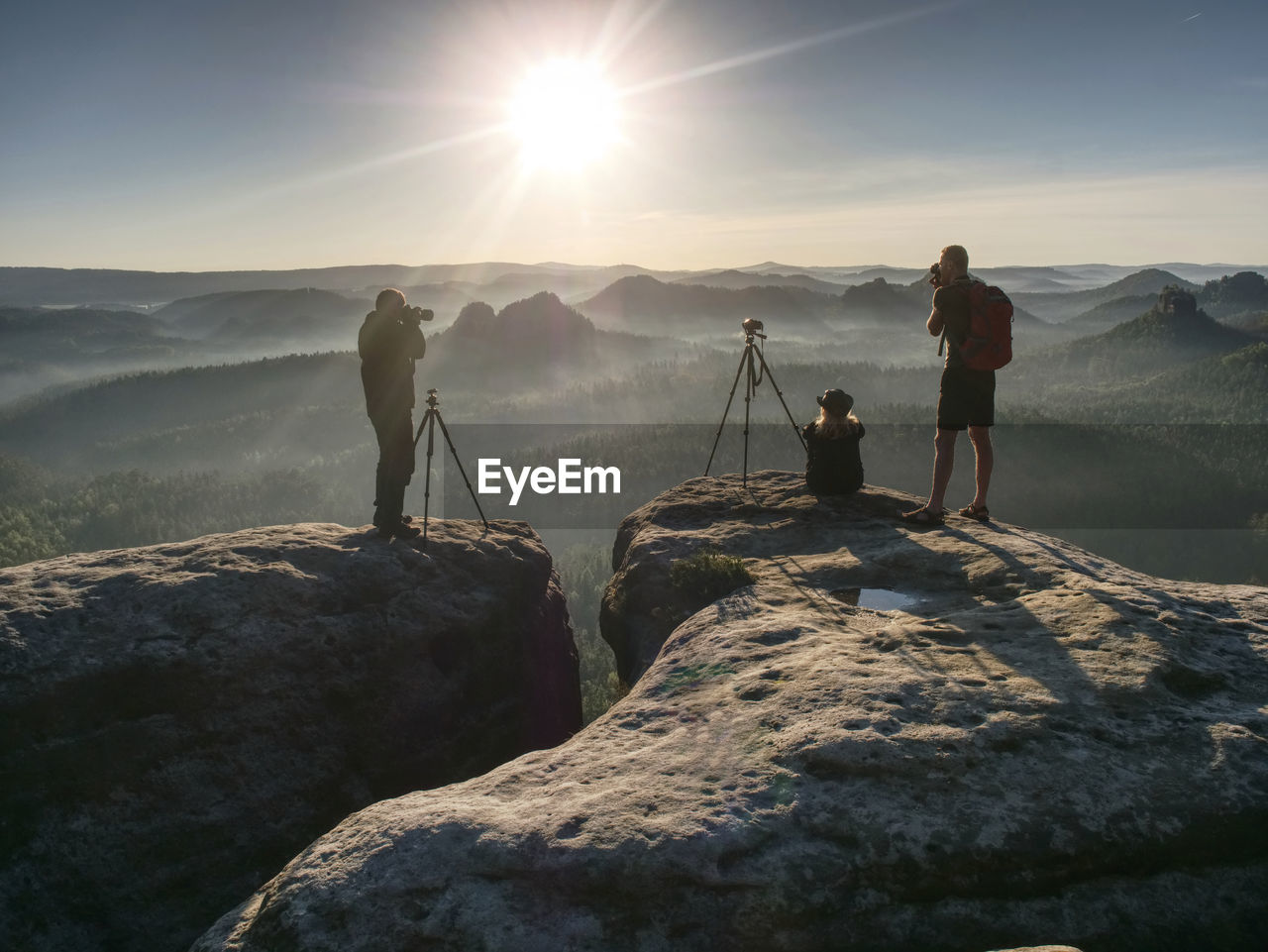 Scenic view of friends photographers taking photo with mountain and more foggy in autumn. 