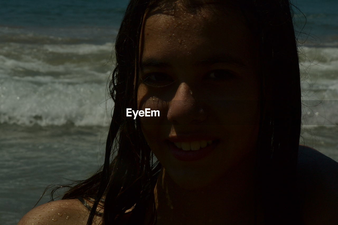 Portrait of smiling teenage girl at beach