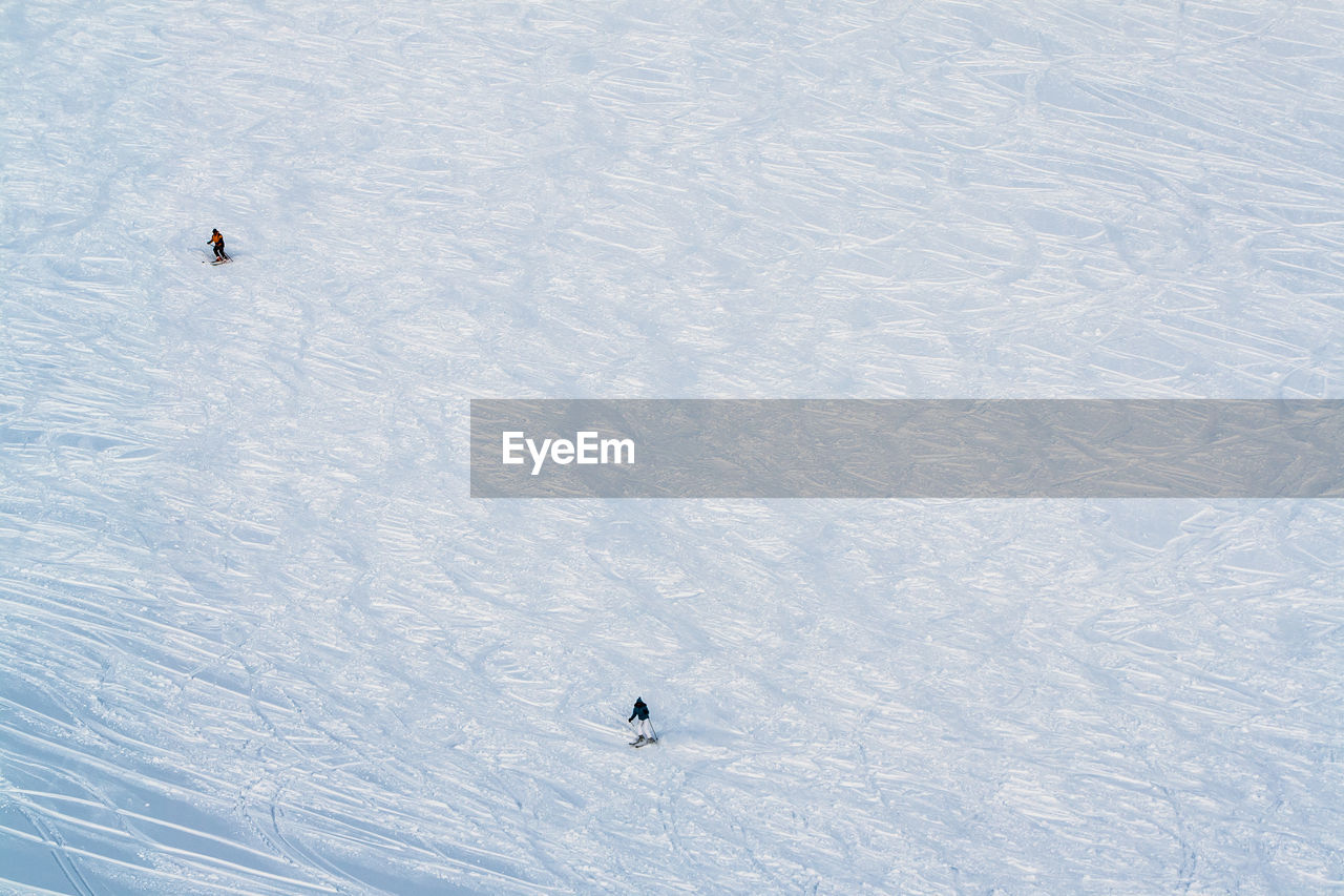 High angle view of people skiing on snow-covered field