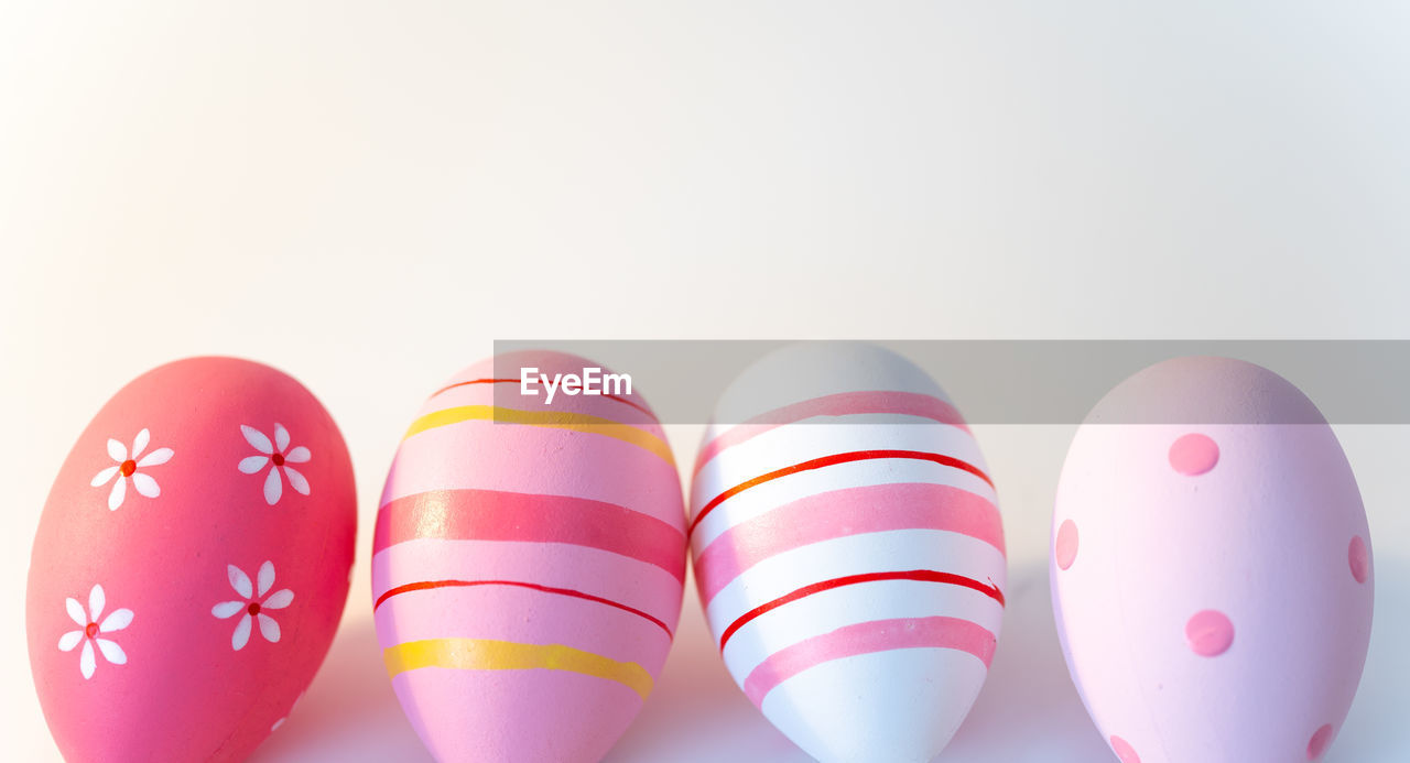 Close-up of multi colored easter eggs on white background