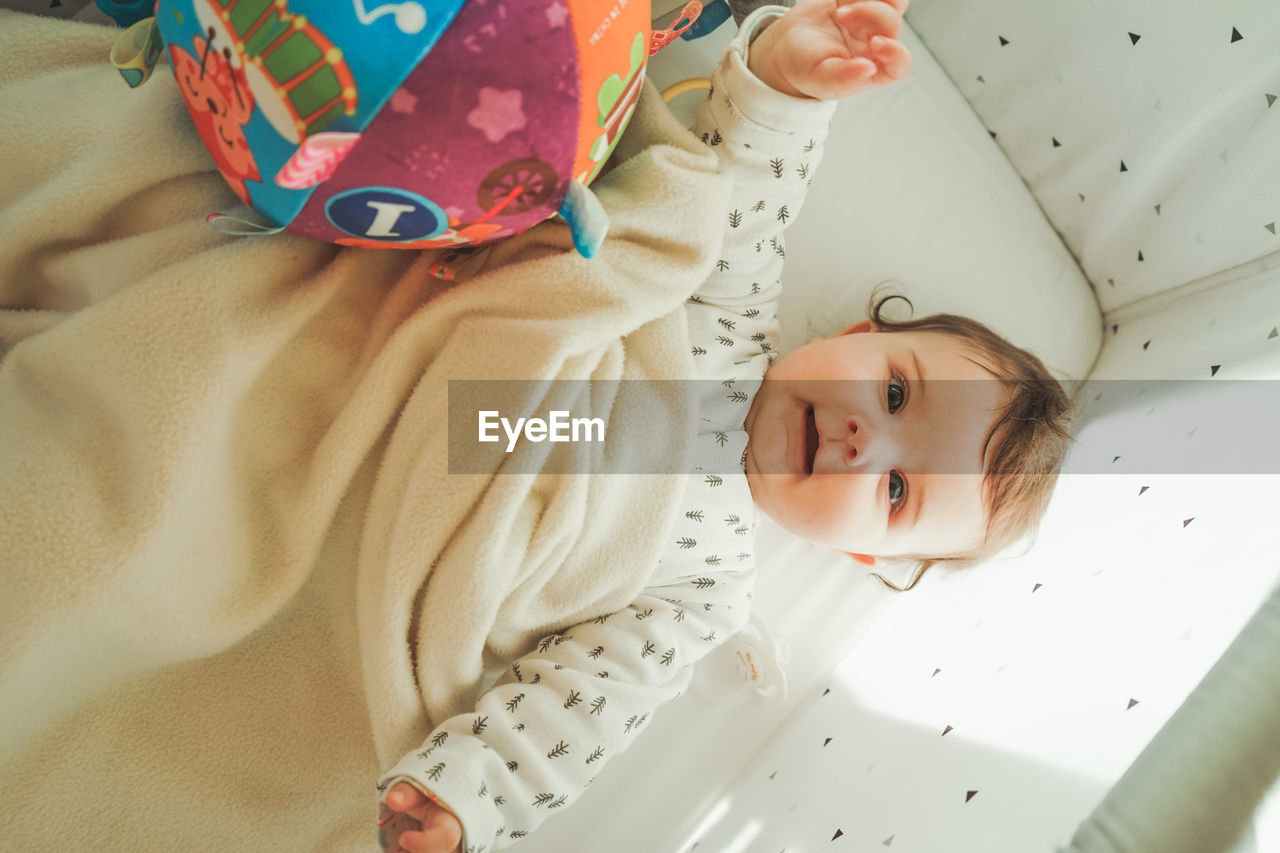 High angle view of cute baby lying on bed