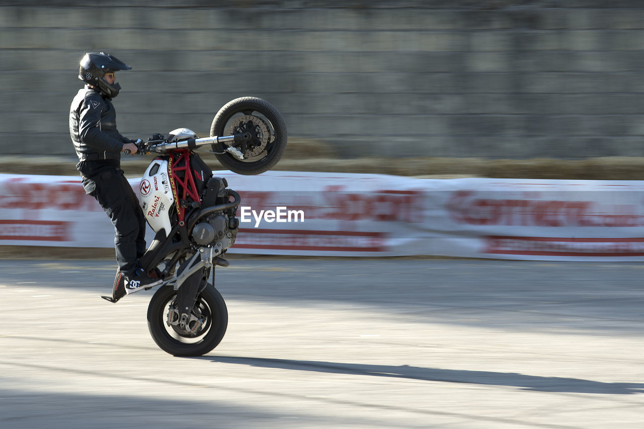 BLURRED MOTION OF MAN RIDING MOTORCYCLE ON BICYCLE