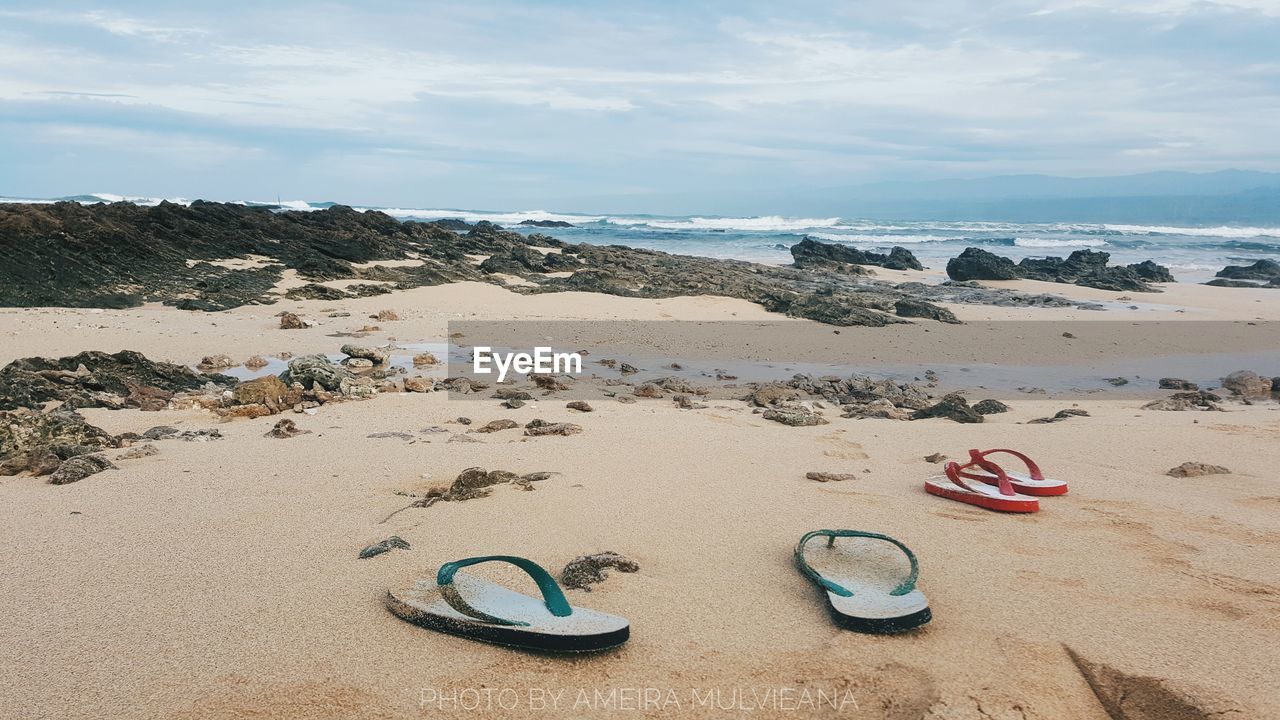 SHOES ON BEACH AGAINST SKY