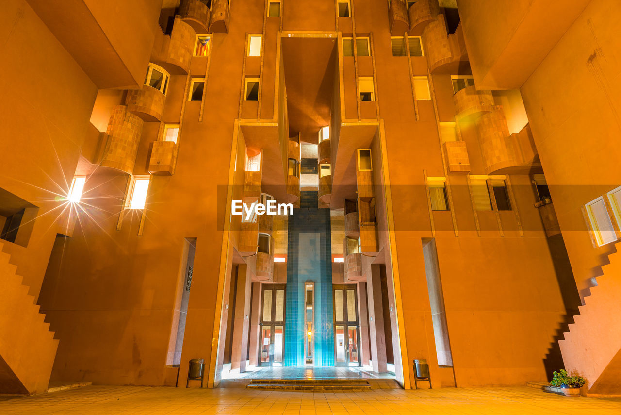 LOW ANGLE VIEW OF ILLUMINATED BUILDINGS IN CITY