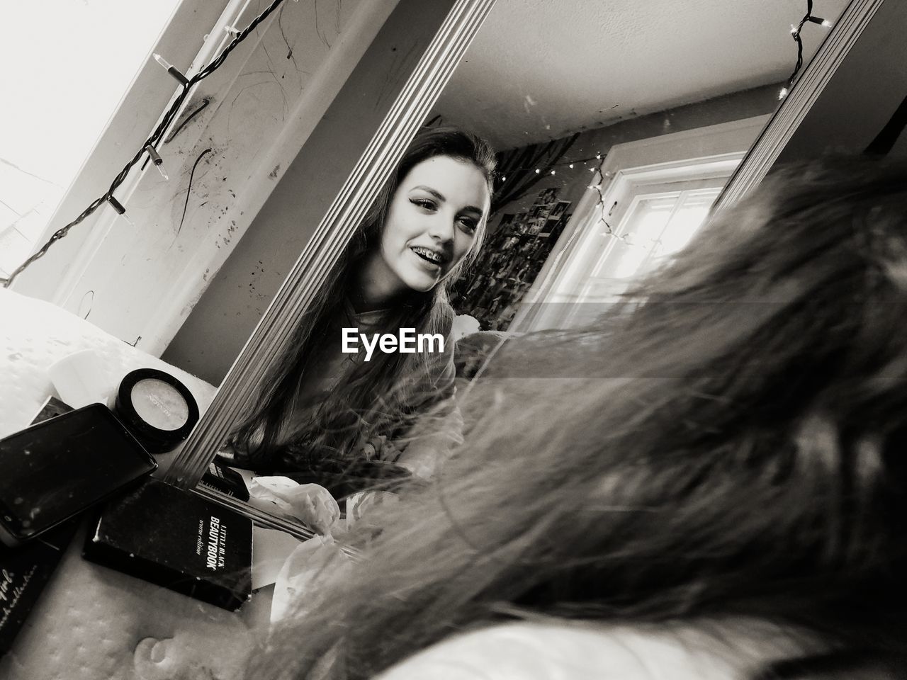 PORTRAIT OF SMILING WOMAN WITH REFLECTION IN WINDOW