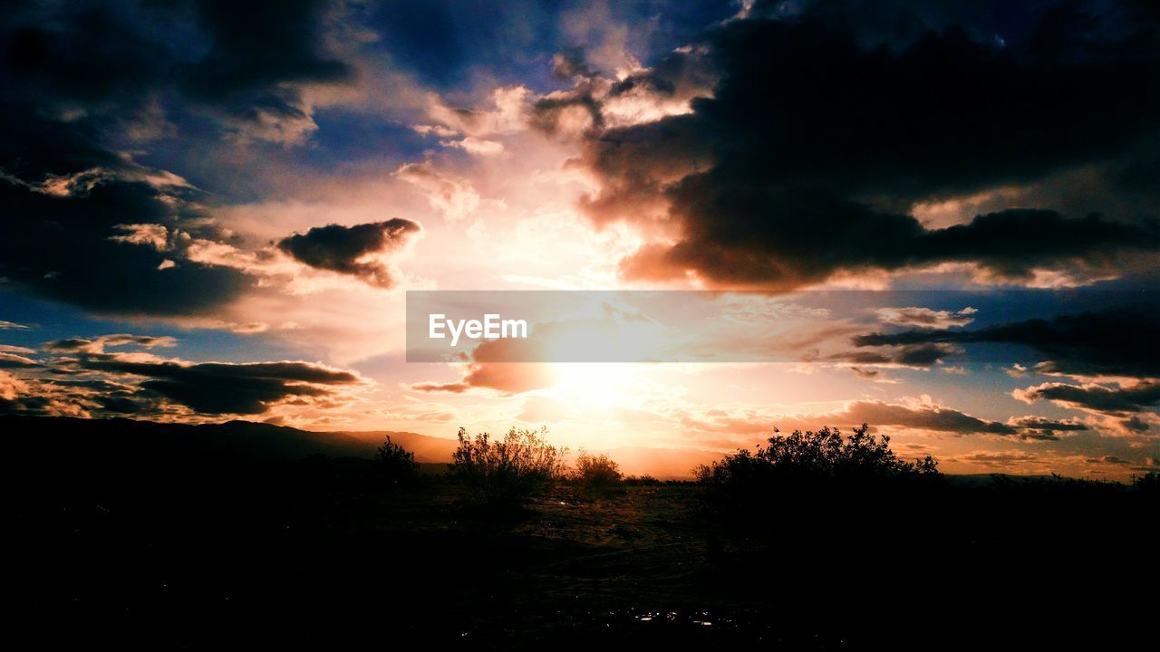 Scenic view of field against cloudy sky