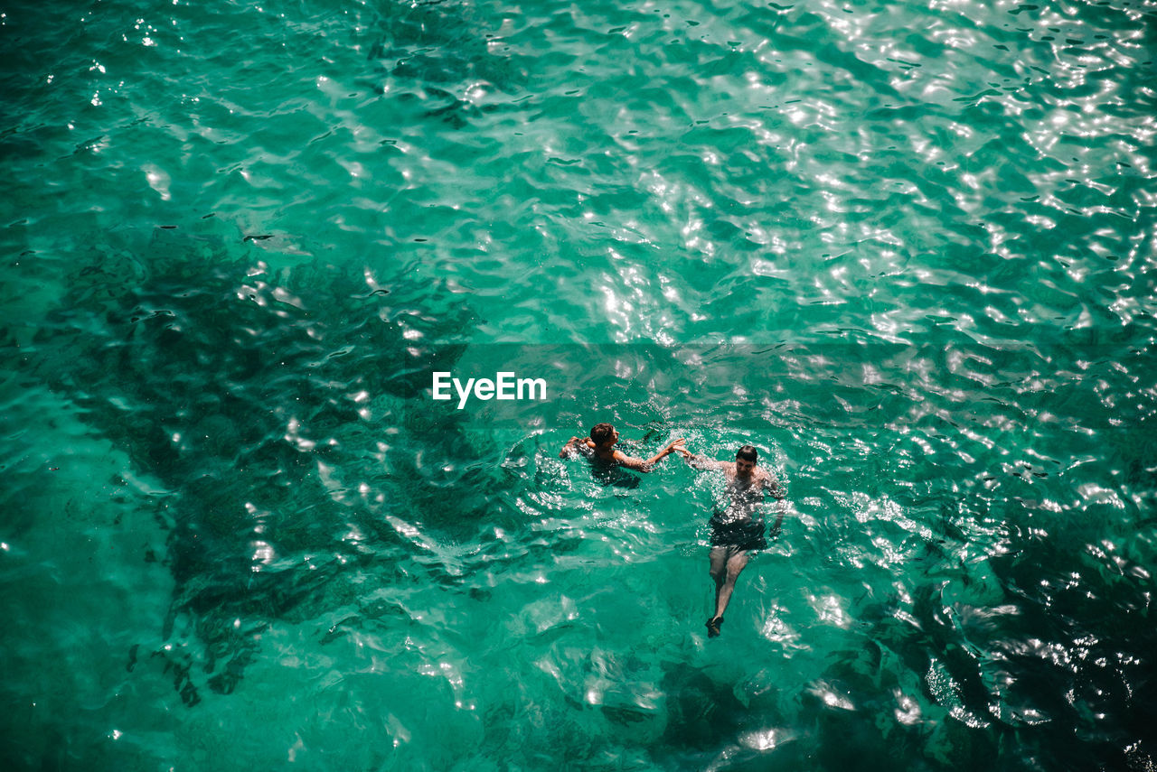 High angle view of men swimming in sea