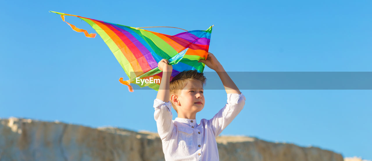 Portrait of a child 8-9 years old with a kite. a blond boy stands and looks into the distance from 