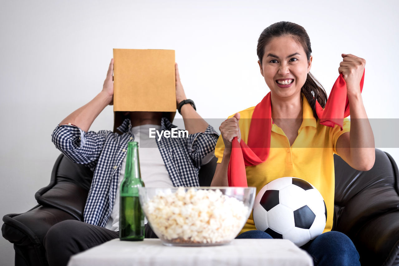 Friends watching sports on tv while sitting at home