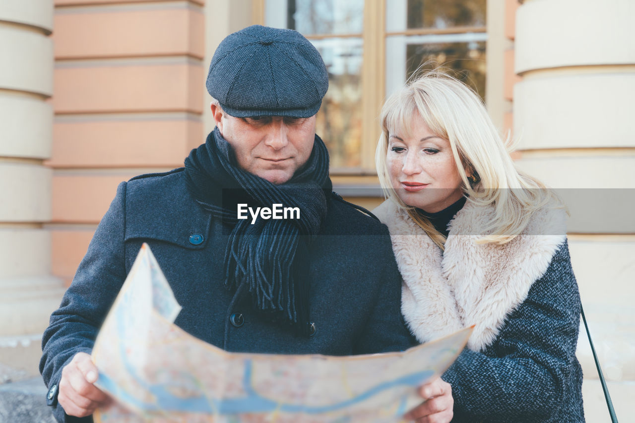 Couple looking at map while standing outdoors