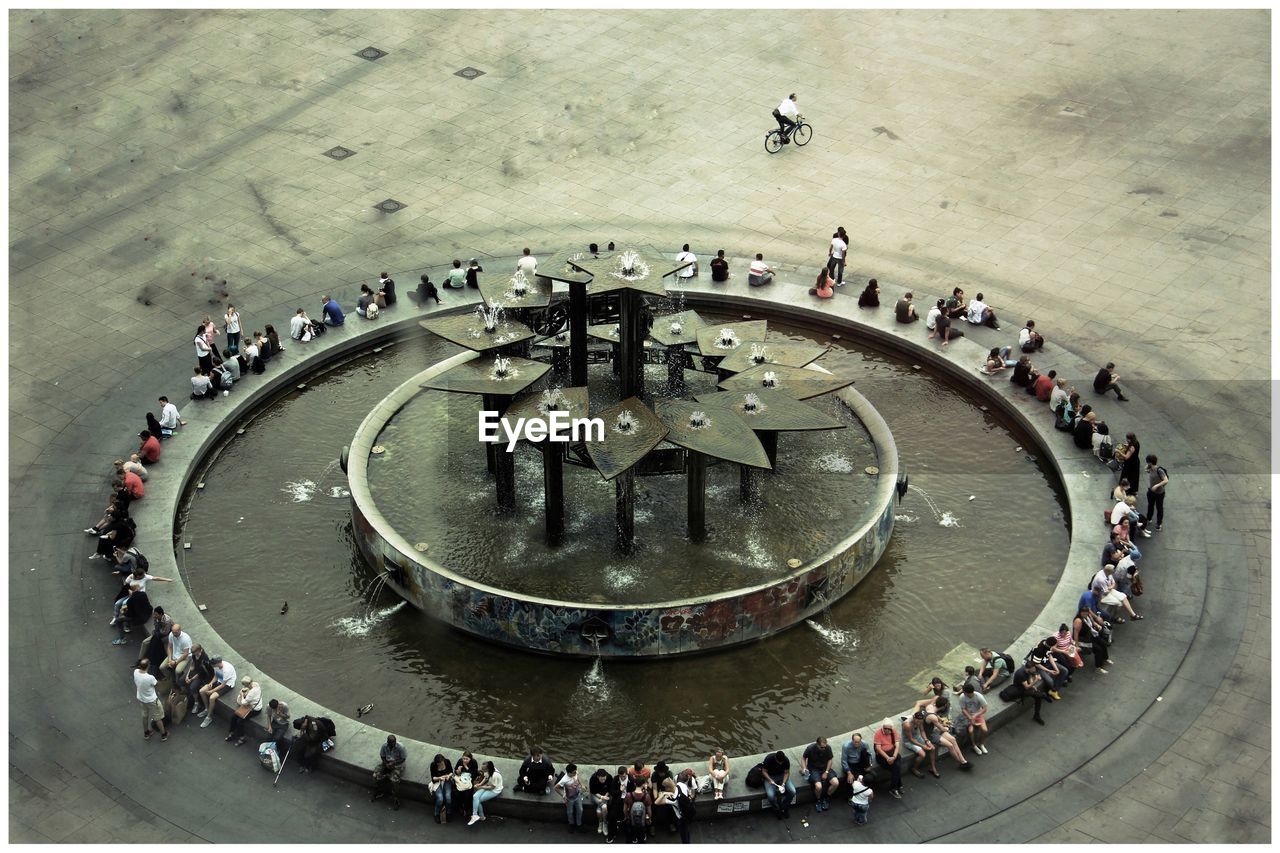 High angle view of people sitting amidst fountain