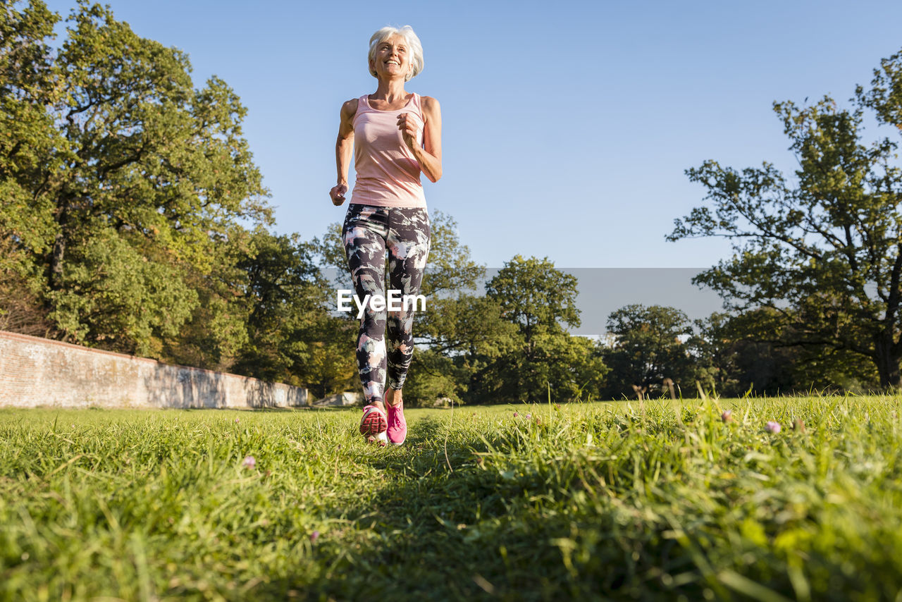 Senior woman running on rural meadow