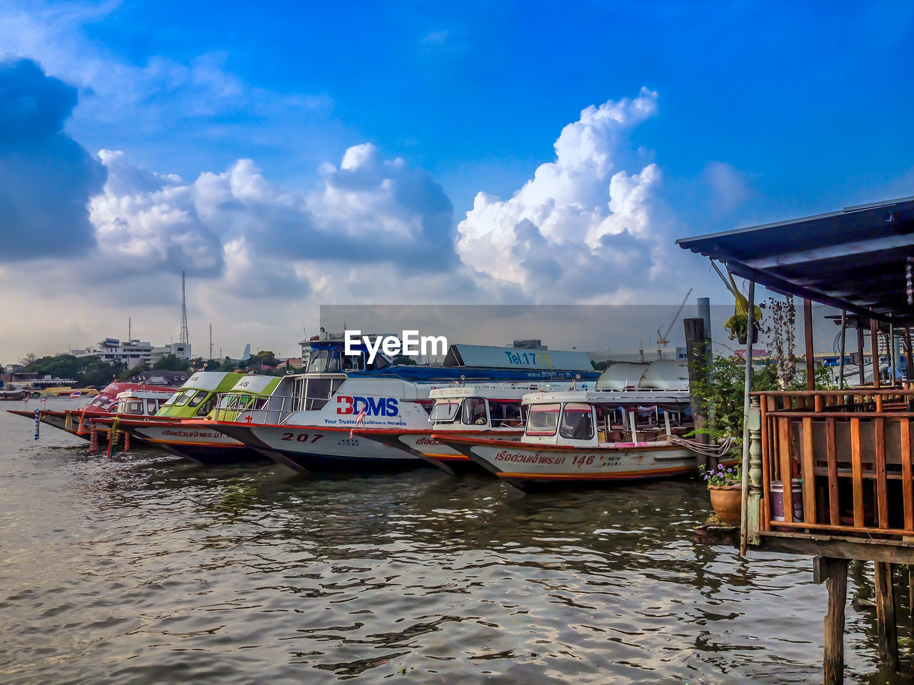 BOATS MOORED IN WATER AGAINST SKY