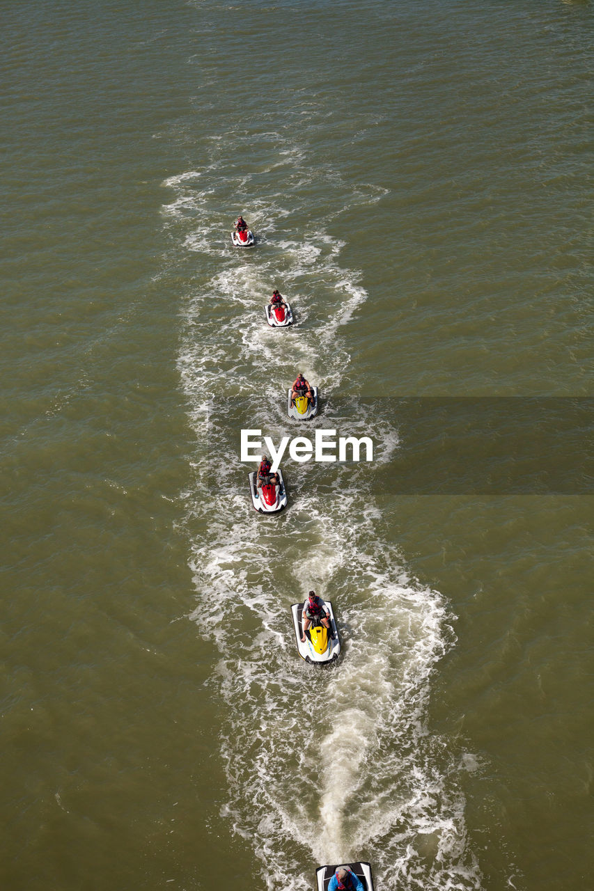 High angle view of people jet boating in sea