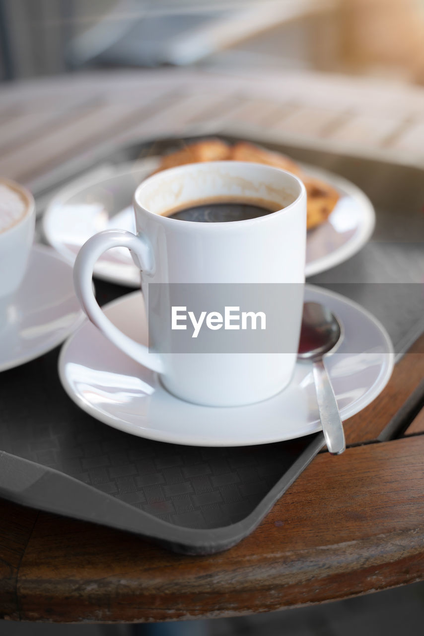 Porcelain cup with coffee on a tablet. mock up offers space for your own designs.