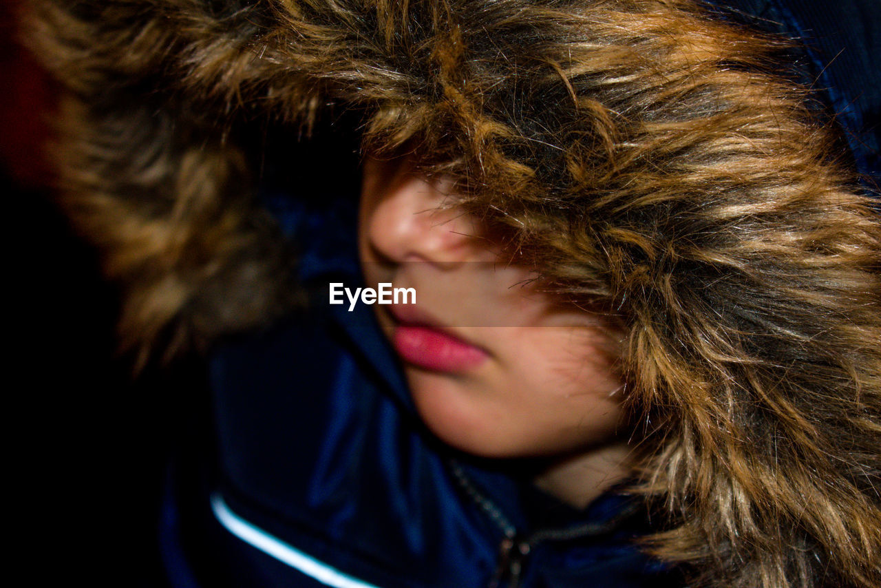 Close-up of boy wearing fur coat