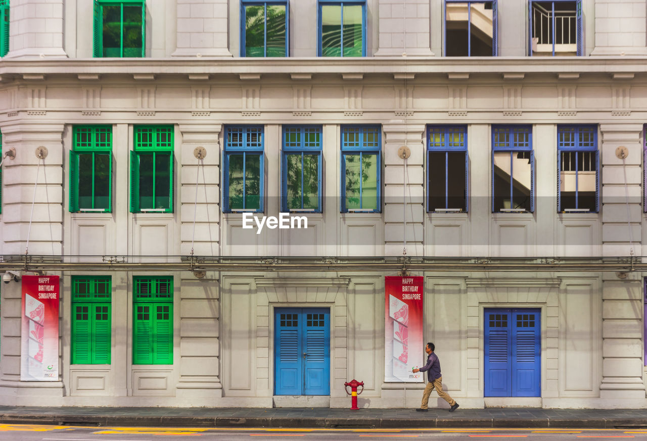 WOMAN STANDING ON STREET BY BUILDING