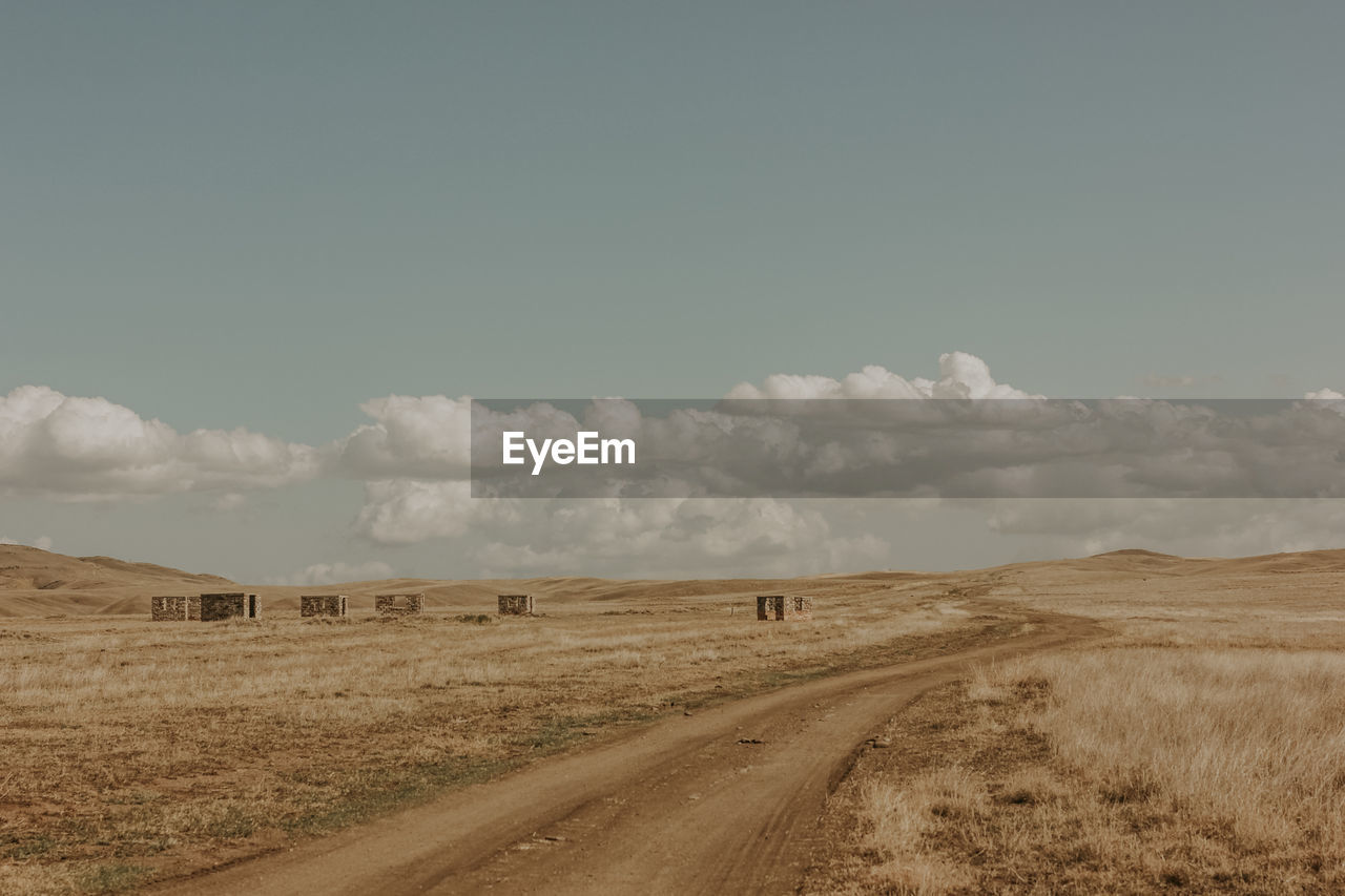 PANORAMIC VIEW OF DIRT ROAD AGAINST SKY