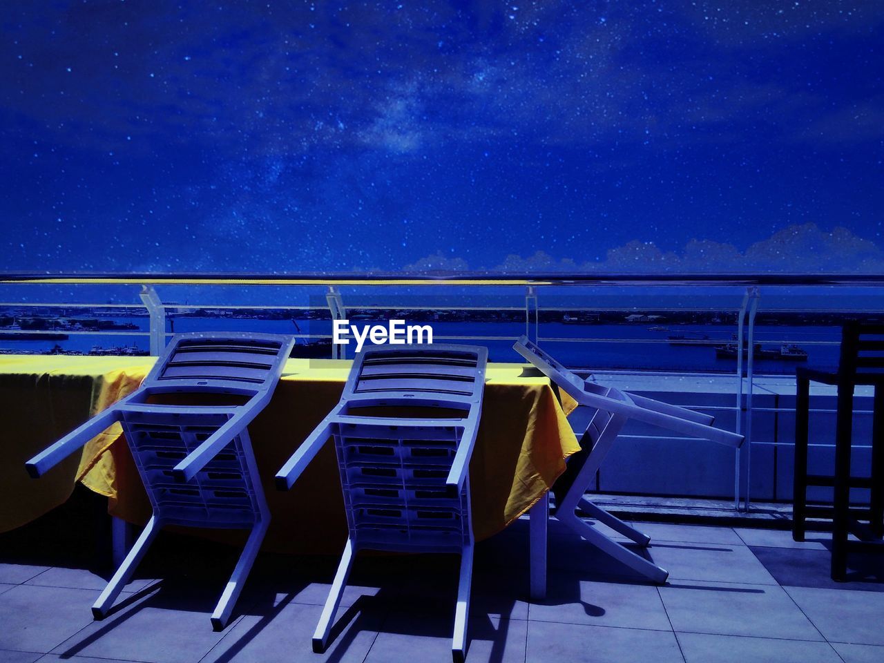 Furniture at observation point against sky at night