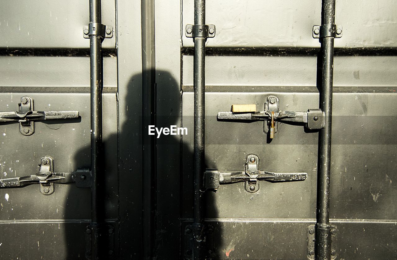 Shadow of person on metallic door