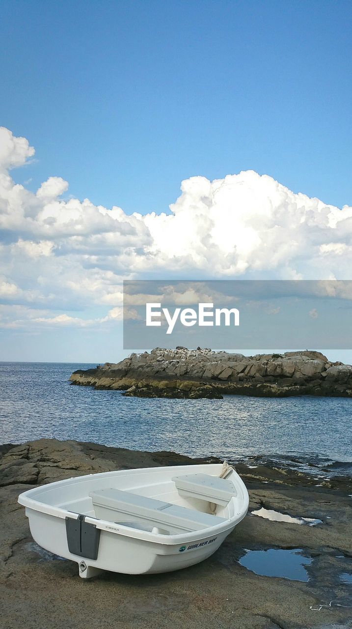 Boat moored on rock against sky at cape neddick