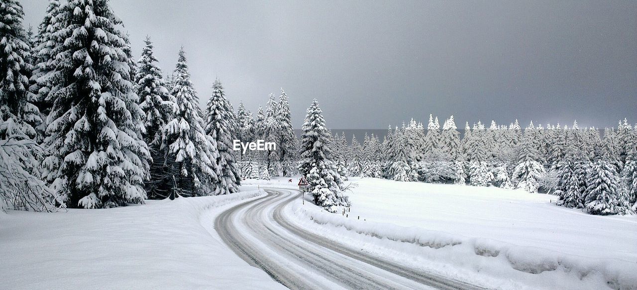 Road passing through snow covered landscape