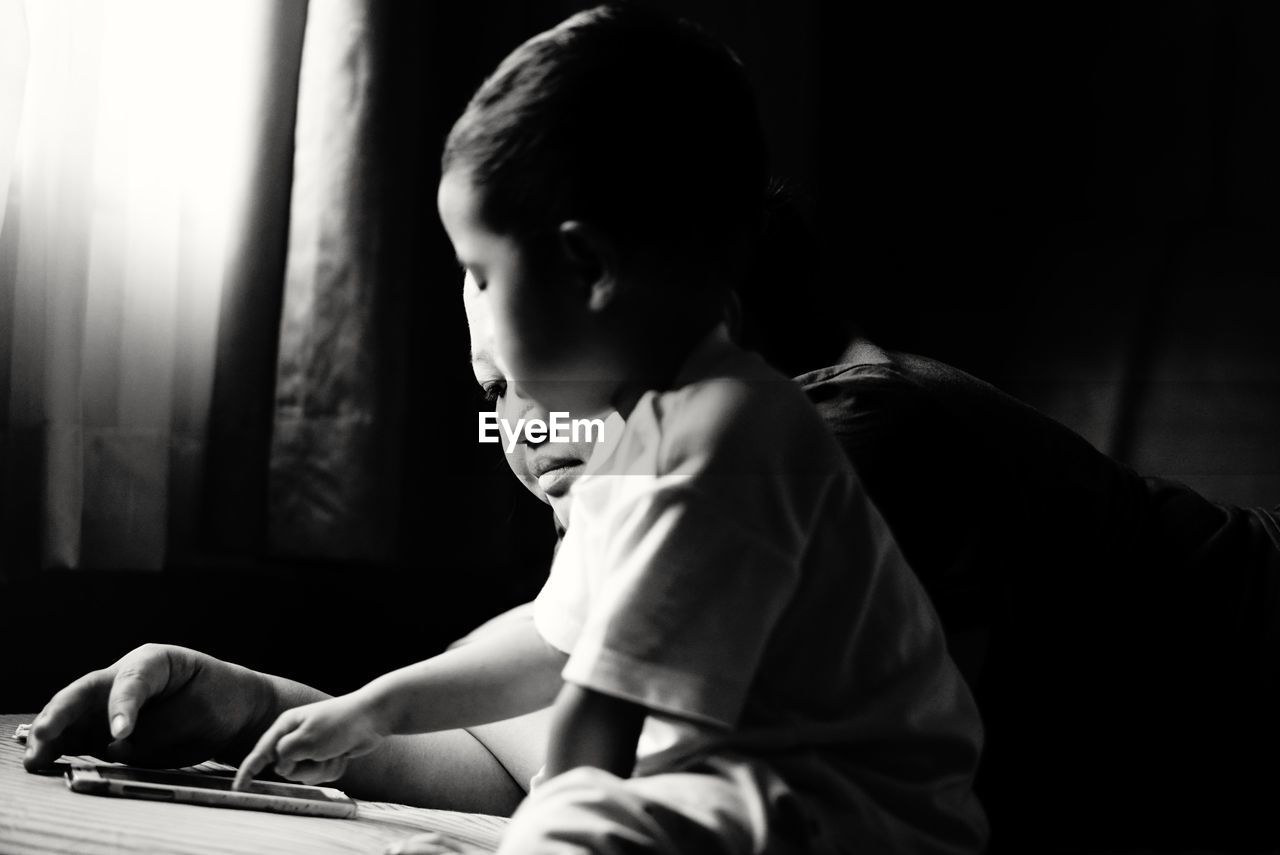 Close-up of mother and son using smart phone